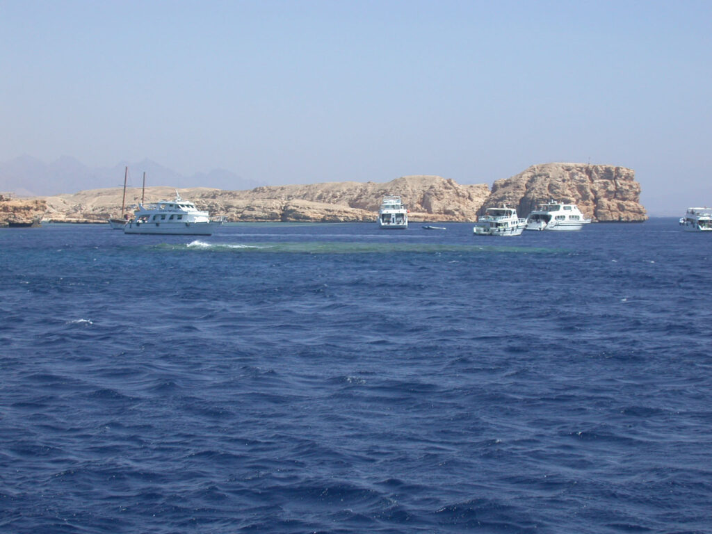 Dykkebåter for anker foran de lyse klippene ved Ras Mohammed, over Shark og Yolanda Reef