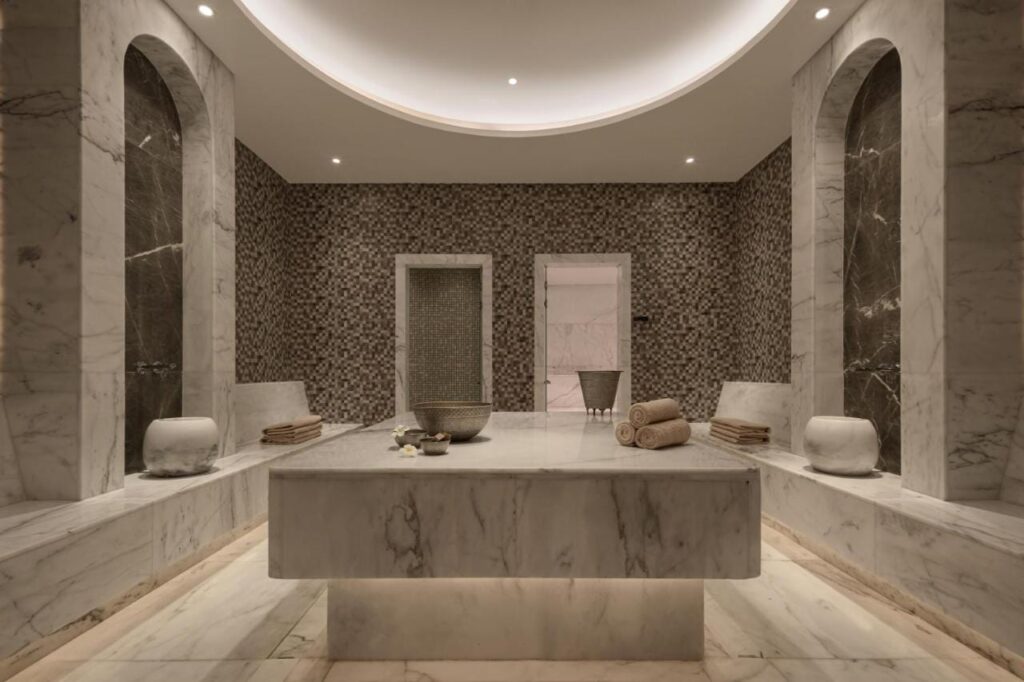 Et spa-rom på JAZ Elite Riviera kledd i marmor, med et stort steinbord i midten