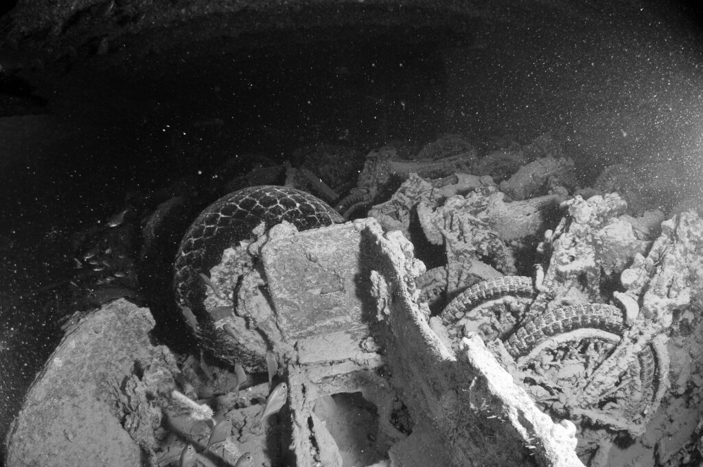 Motorsykler stablet i lasterommet på Thistlegorm, svart-hvitt-bilde, med dekk og hjul fortsatt synlige
